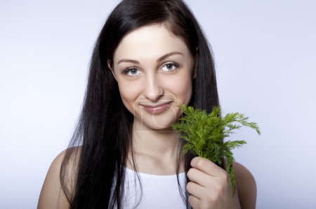 Portrait beautiful young woman smiling holding green dill