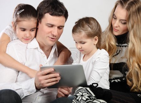 Happy young family using a tablet computer