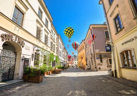 Lublin, Poland - August 10, 2017: Beautiful street and old bright buildings in the old town of Lublin, Poland. Center of Lublin, Brama street. Mountebanks Carnaval in Lublin old town.
