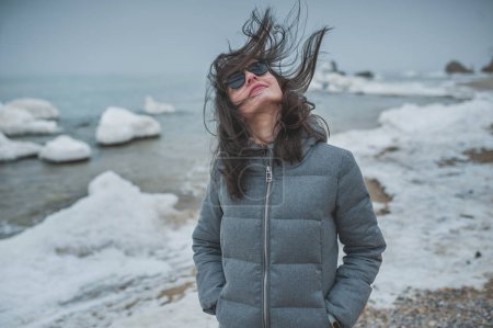 beautiful girl with hair on her face from the wind on the beach