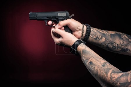 Close-up view of male hands aiming with gun