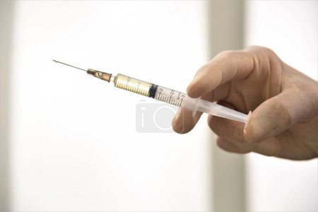 hand in glove holding syringe drug for injection
