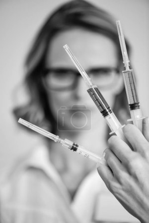Doctor holding syringes
