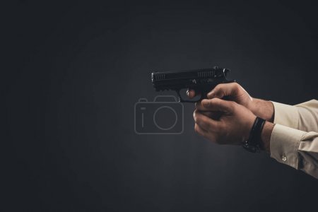 cropped shot of man holding gun isolated on black