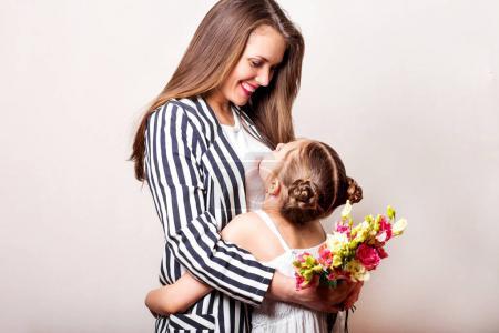 daughter gives flowers to her mother on her mother's day