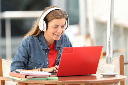 Happy student listening a video tutorial on line