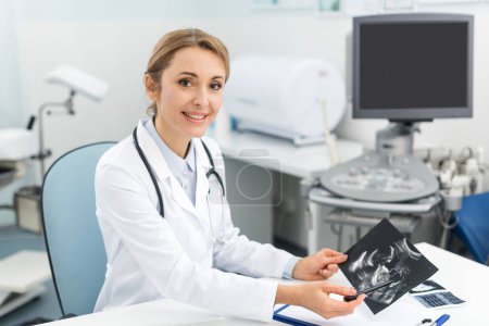 professional female doctor showing ultrasound scan in clinic 