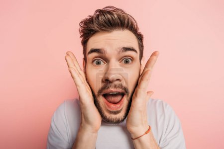 shocked man with crazy face expression looking at camera on pink background