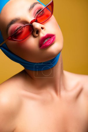 naked fashionable girl in trendy scarf and red sunglasses, isolated on yellow