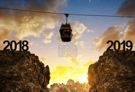 New Year 2019 concept. The mountain cable car moving above the abyss at sunset.