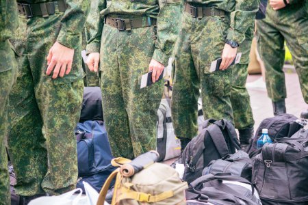 cadets conscripts in uniform stand in line with bags and backpacks