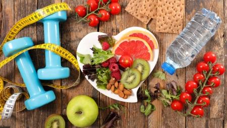 bowl with breakfast and water bottle with measuring tape and dumbbells, healthy food concept 