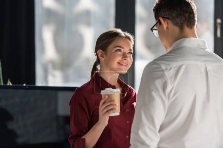 attractive young manageress with coffee to go flirting with colleague