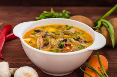 Delicious soup with smoked chicken, mushrooms,  eggs and cream. Wooden background
