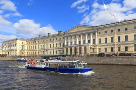 Tour boat on the background of the Russian National Library. The