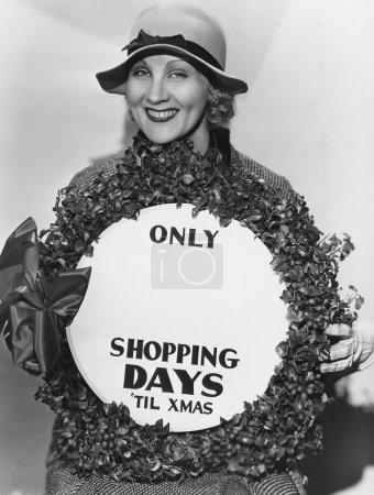 Woman with sign with number of shopping days until Christmas