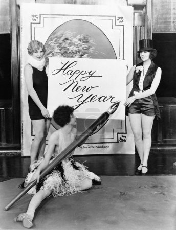 Women writing Happy New Year with huge pen