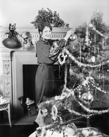 Young woman decorating a Christmas tree