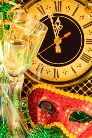 Christmas card. Glasses of champagne on New Year's Eve against an ancient wall clock