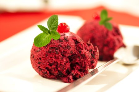 Ice-cream globule with a currant and mint on a red napkin