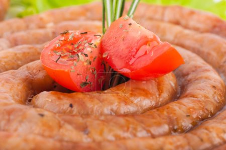 Sausage from pork and beef with tomatoes and spices, vegetable salad