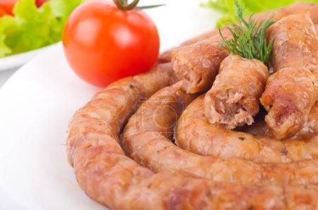 Sausage from pork and beef with tomatoes and spices, vegetable salad