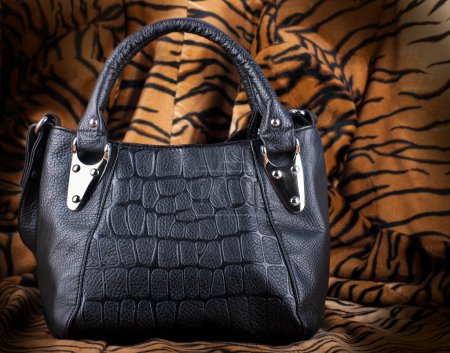 Bag black, leather against a skin of a tiger