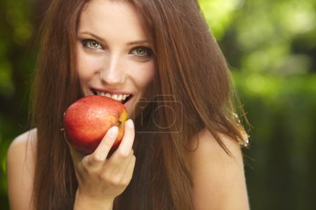Woman with apple in garden