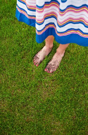 Muddy feet with red nails - gardening concept