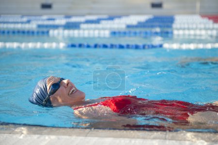 Active Senior woman swimming in pool