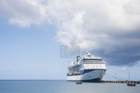 Blue and White Cruise Ship Docked Under Storm Cloud