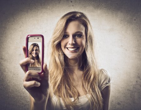 Young woman taking photos with a mobile phone
