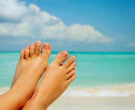 Vacation Concept. Woman's Bare Feet over Sea background