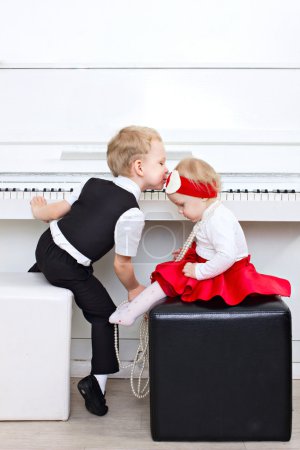 Little children sitting near piano